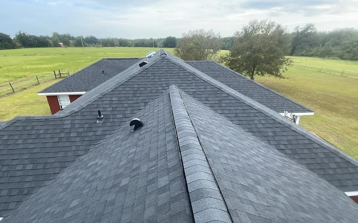 Aerial view along the ridge of a finished dark architectural shingle roof on a rural Baldwin County home