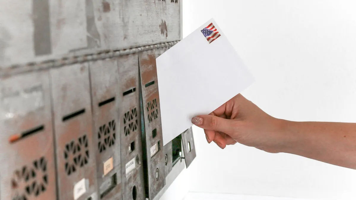 A single letter being pulled from a bank of residential mailboxes
