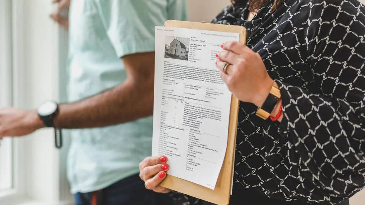 A printed estimate on a clipboard being handed across to the person paying for the work