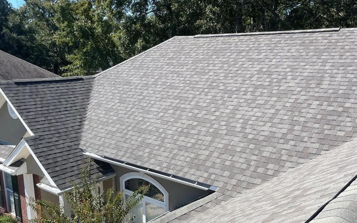 Finished architectural shingle roof on a brick Baldwin County home, laminated shingle courses visible from above