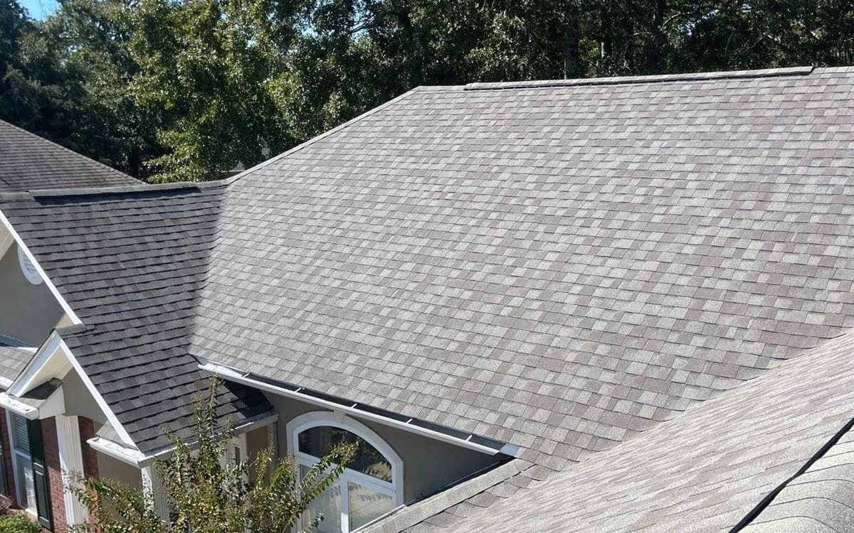 Finished architectural shingle roof on a brick Baldwin County home, laminated shingle courses visible from above