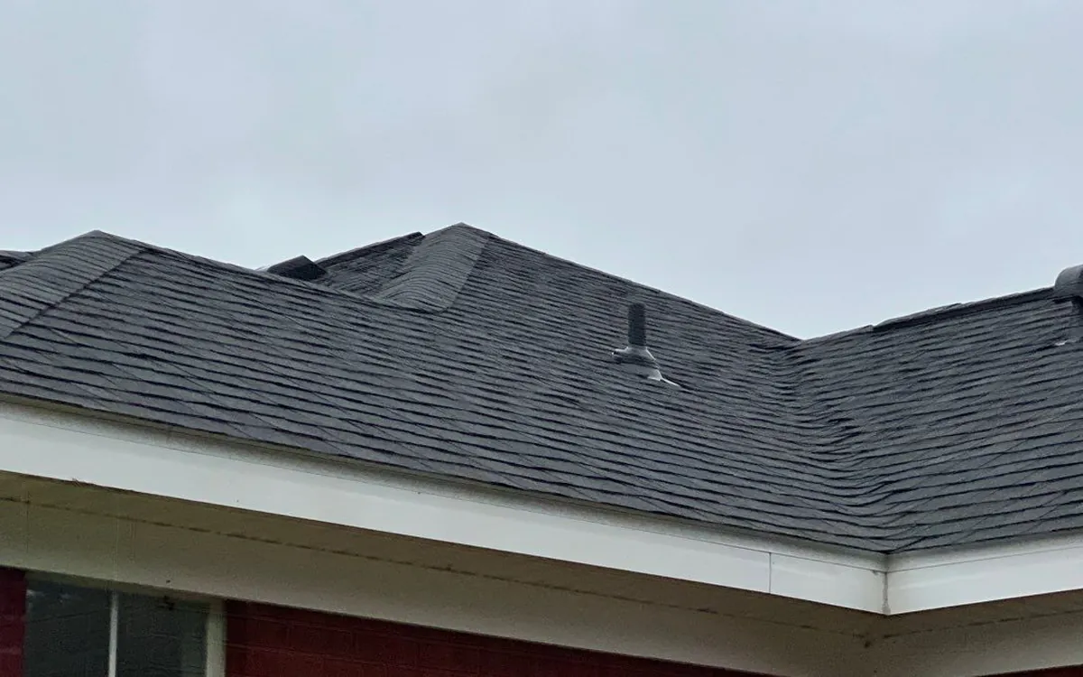 Eave, gutter line and drip edge along the perimeter of a dark shingle roof on a brick Alabama home